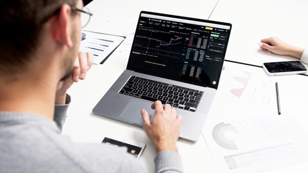 Homem analisando investimentos em criptomoedas e shitcoins.